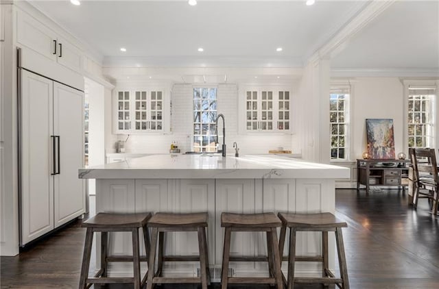 kitchen with dark hardwood / wood-style flooring, plenty of natural light, and a center island with sink