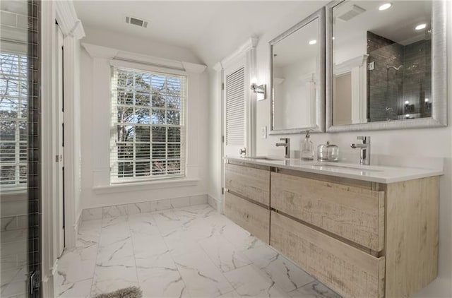 bathroom with a wealth of natural light, tiled shower, vanity, and tile patterned floors