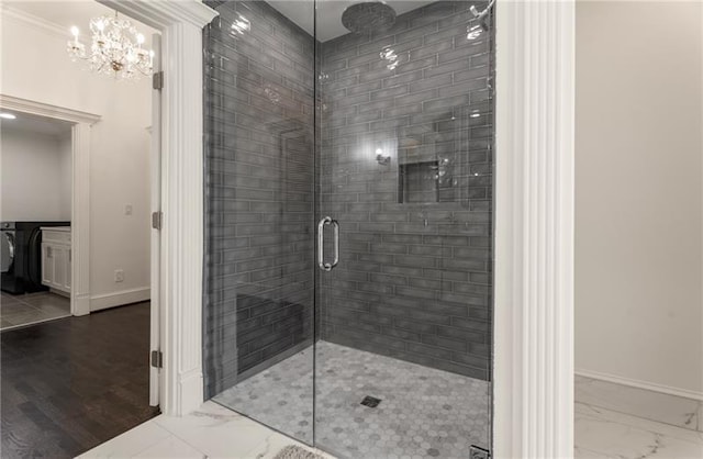 bathroom featuring tile patterned floors, an inviting chandelier, crown molding, and walk in shower