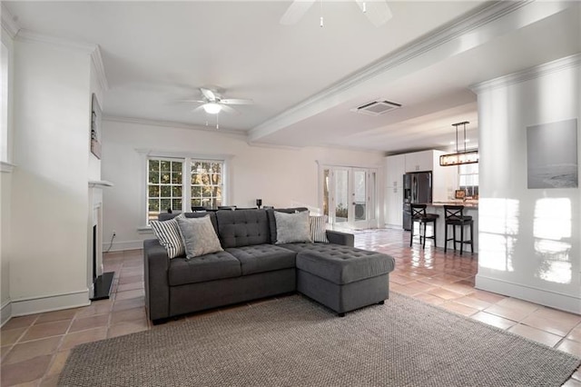 living room with ceiling fan with notable chandelier, light tile patterned floors, and ornamental molding