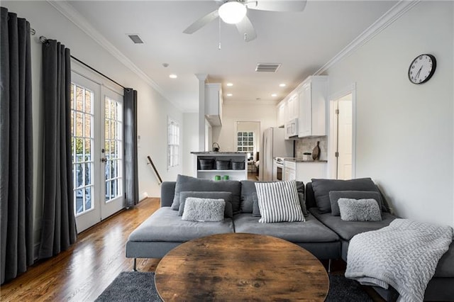 living room with french doors, crown molding, a healthy amount of sunlight, and wood-type flooring