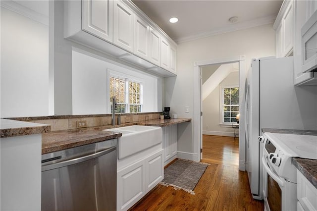 kitchen with a wealth of natural light, dark hardwood / wood-style floors, white appliances, and white cabinets