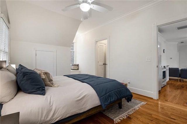 bedroom with hardwood / wood-style flooring, crown molding, lofted ceiling, and ceiling fan