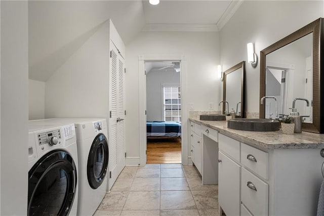 clothes washing area with ceiling fan, washing machine and clothes dryer, light hardwood / wood-style flooring, ornamental molding, and sink