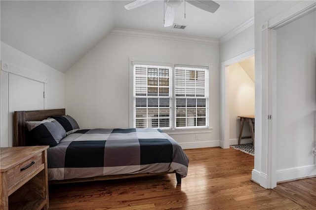 bedroom featuring ceiling fan, light hardwood / wood-style flooring, ornamental molding, and lofted ceiling