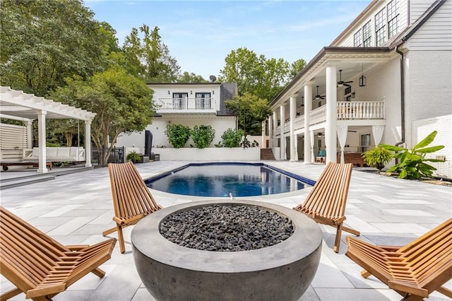 view of pool featuring a patio, an outdoor fire pit, and ceiling fan