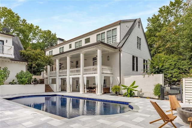 back of house featuring a patio area, a balcony, and a fenced in pool