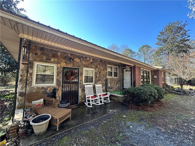 exterior space with stone siding and covered porch