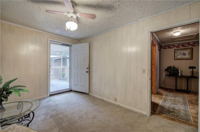 interior space with a textured ceiling, carpet floors, and ornamental molding