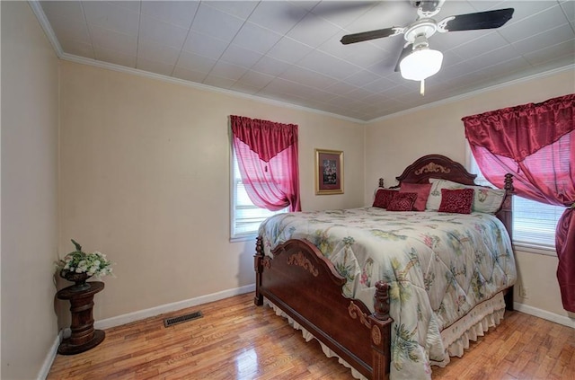 bedroom featuring ornamental molding, light wood-type flooring, and ceiling fan