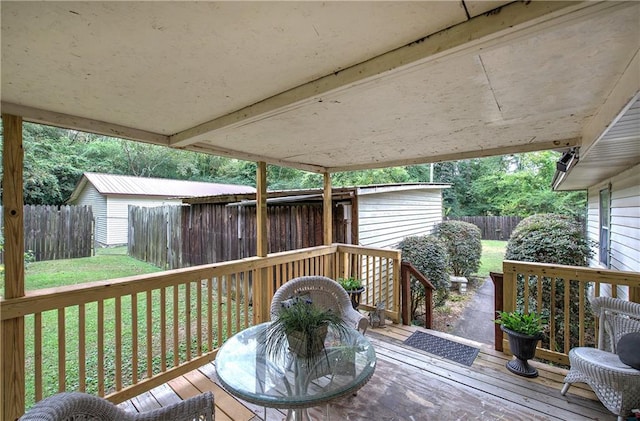 deck featuring a storage shed and a yard