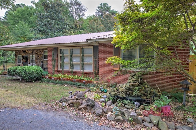 view of front facade featuring brick siding and metal roof