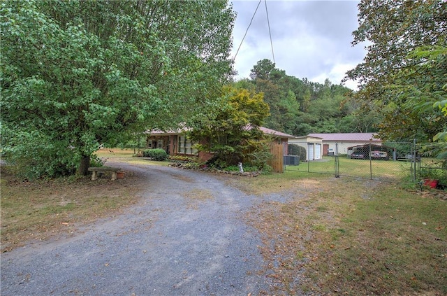 ranch-style home featuring a gate, a front yard, and fence