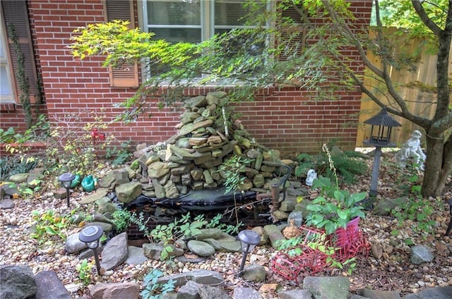 details featuring brick siding and a small pond