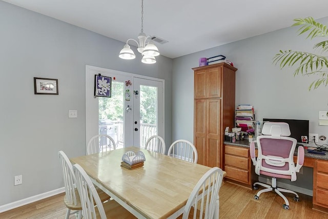 dining room with light wood-style flooring, a desk, a chandelier, and baseboards