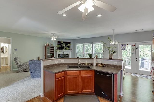 kitchen featuring dishwasher, a sink, ceiling fan, open floor plan, and a fireplace