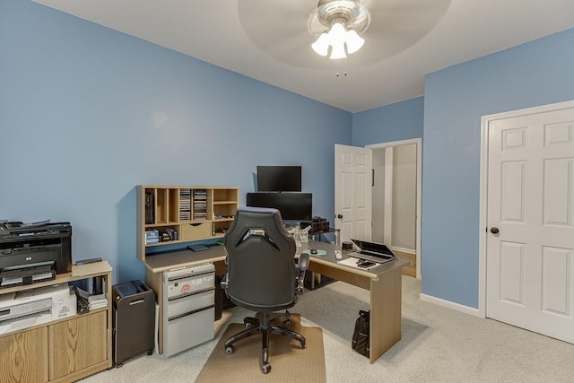 office area with a ceiling fan, light colored carpet, and baseboards