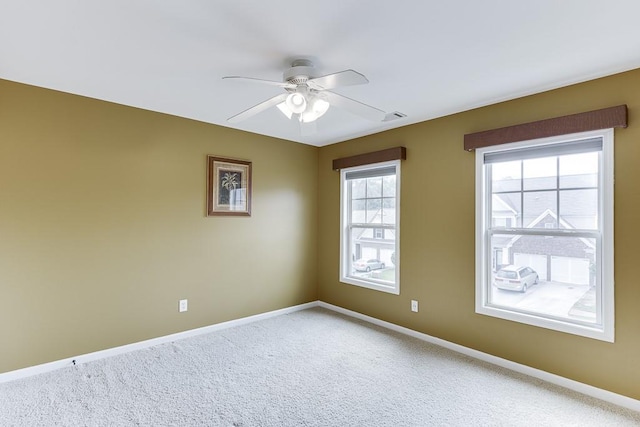 unfurnished room featuring a ceiling fan, baseboards, and carpet