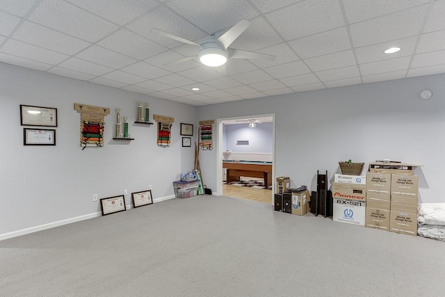 below grade area with ceiling fan, carpet, baseboards, a drop ceiling, and recessed lighting