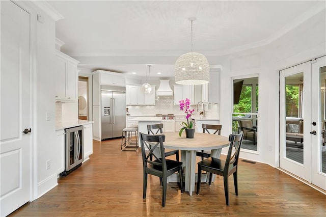 dining room with recessed lighting, visible vents, french doors, wood finished floors, and beverage cooler