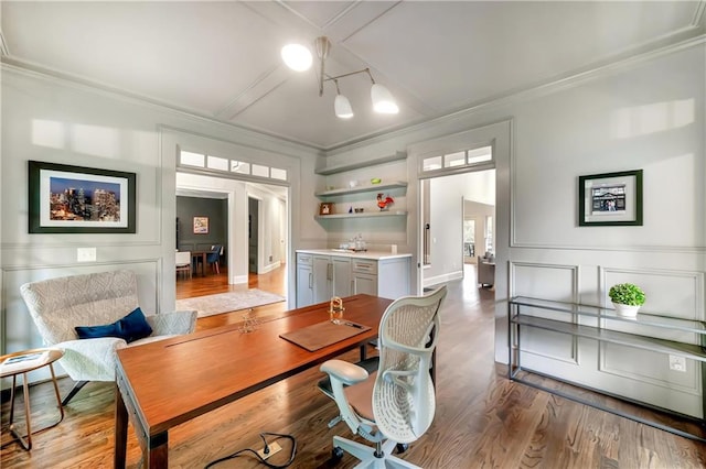 office space featuring wood finished floors, a decorative wall, and ornamental molding