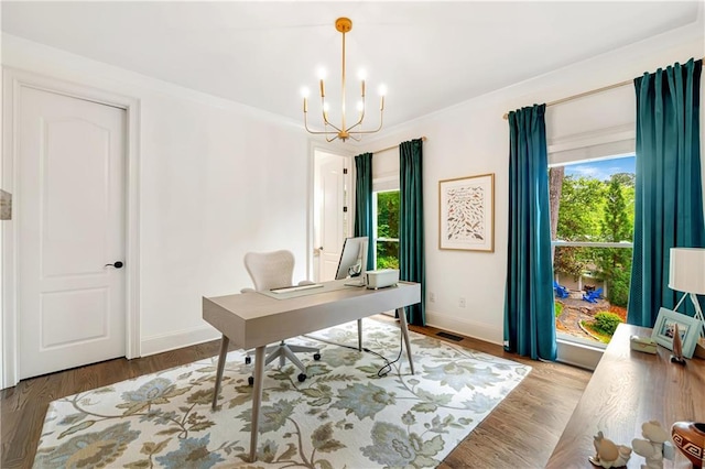 office featuring visible vents, a notable chandelier, wood finished floors, and baseboards