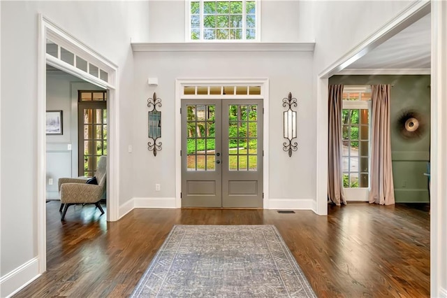 foyer featuring a high ceiling, wood finished floors, french doors, and baseboards