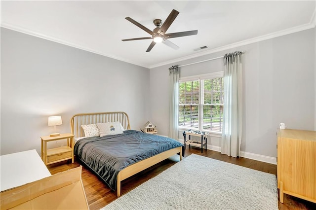 bedroom featuring wood finished floors, ceiling fan, baseboards, visible vents, and crown molding