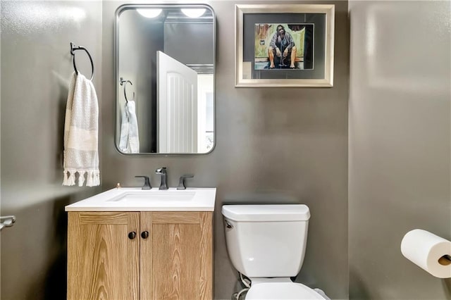 half bathroom with vanity and toilet
