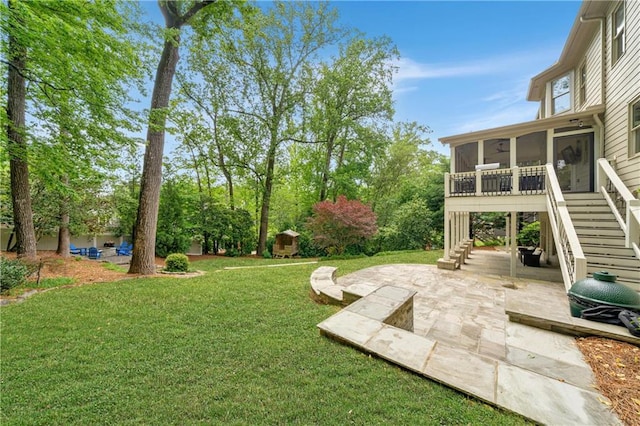 view of yard featuring a sunroom, stairway, and a patio area