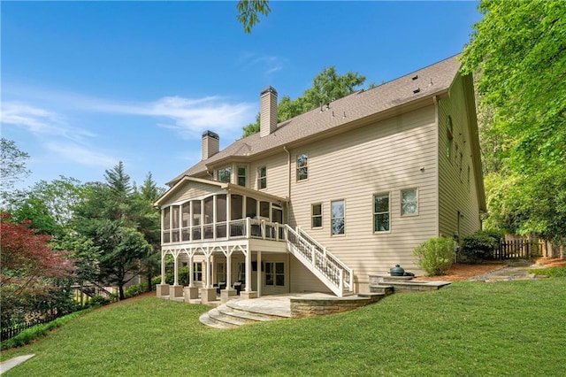 back of house with a sunroom, a patio, stairway, a yard, and a chimney