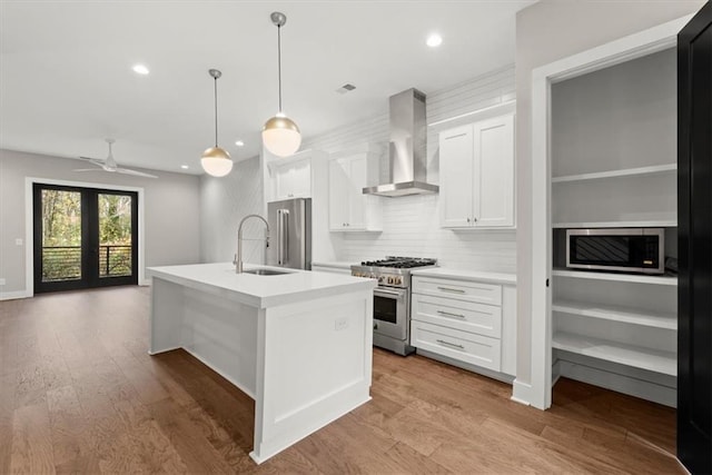 2329 Mason Dr Unit D24, Atlanta, GA 30316 - kitchen featuring high end appliances, wall chimney exhaust hood, a sink, an island with sink, and white cabinetry