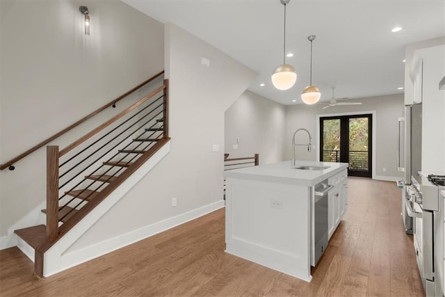 2329 Mason Dr Unit D24, Atlanta, GA 30316 - kitchen featuring a sink, stainless steel appliances, white cabinets, light wood-style floors, and light countertops