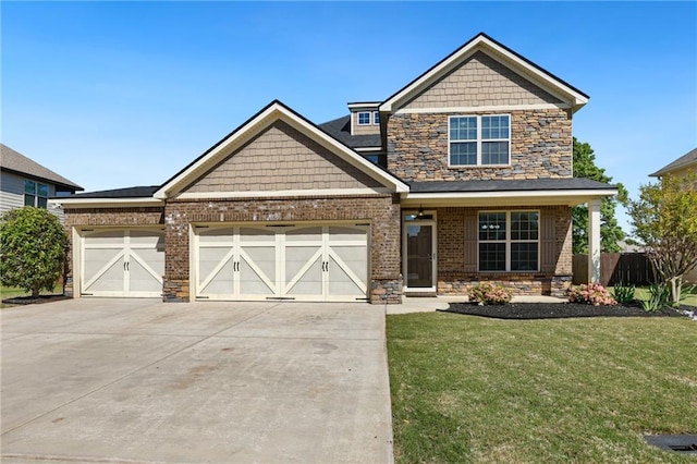 craftsman house with driveway, stone siding, a front lawn, brick siding, and a garage