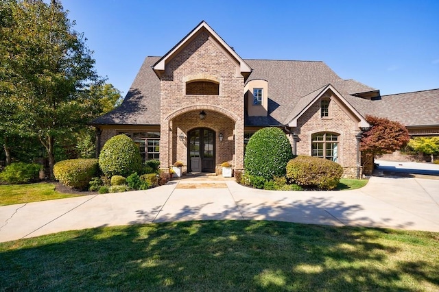 french country inspired facade featuring a front yard