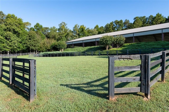 view of gate with a rural view and a yard