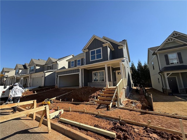 view of front of home with a residential view, covered porch, board and batten siding, and a garage