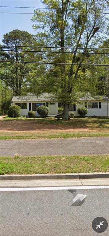 view of property hidden behind natural elements with a front yard