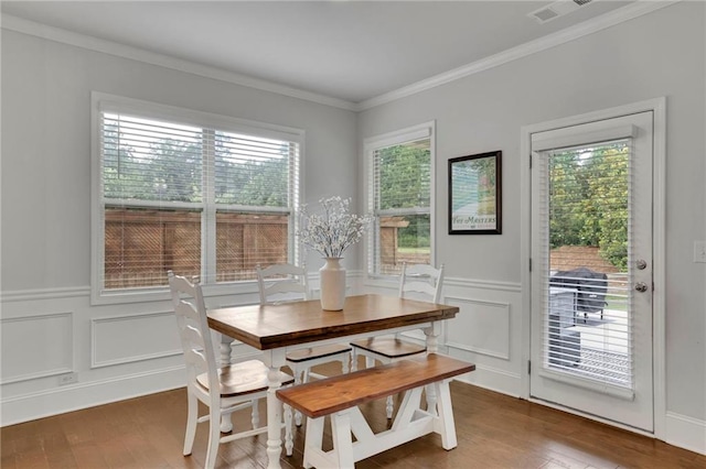 3940 Frasier Dr, Cumming, GA 30028 - dining space featuring a decorative wall, wood finished floors, ornamental molding, and a wainscoted wall