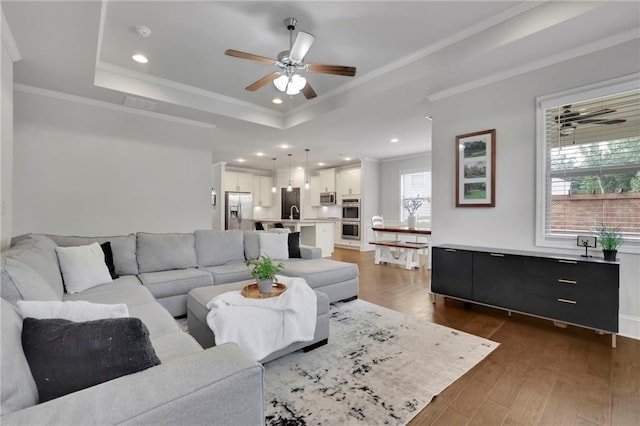 3940 Frasier Dr, Cumming, GA 30028 - living room featuring a ceiling fan, a raised ceiling, dark wood-type flooring, recessed lighting, and ornamental molding