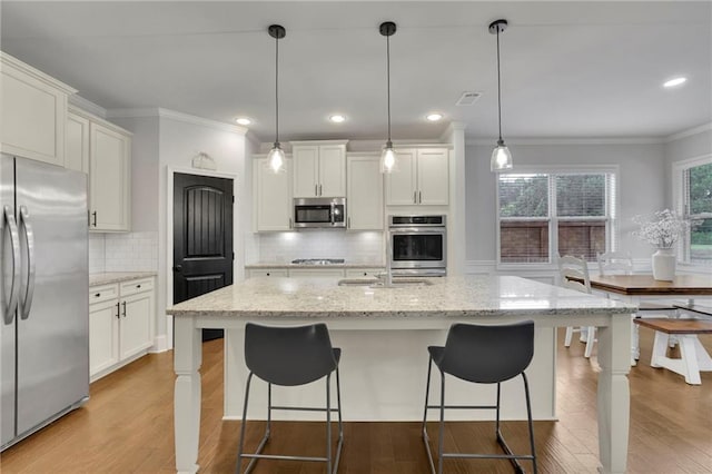3940 Frasier Dr, Cumming, GA 30028 - kitchen with stainless steel appliances, crown molding, tasteful backsplash, light wood-style flooring, and light stone counters