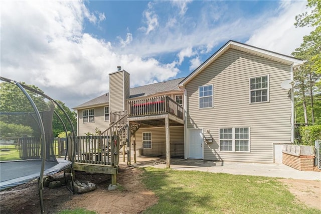 1623 Pratt Rd, Covington, GA 30014 - rear view of property with a patio area, a trampoline, a wooden deck, a lawn, and a chimney