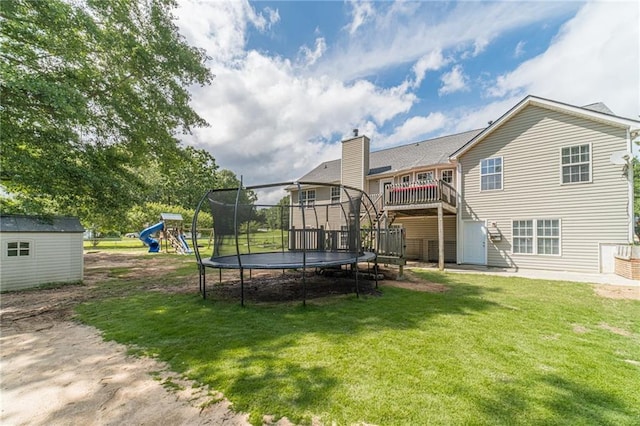 1623 Pratt Rd, Covington, GA 30014 - rear view of house with a trampoline, a lawn, stairway, a deck, and a playground