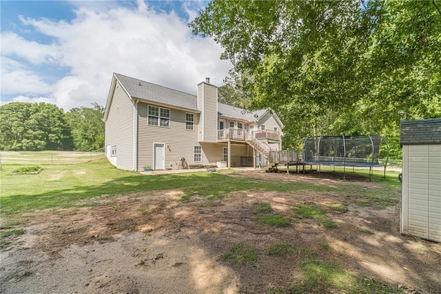 1623 Pratt Rd, Covington, GA 30014 - back of property with a trampoline, a deck, a yard, a chimney, and a patio