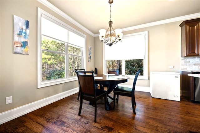 dining room with crown molding, dark hardwood / wood-style flooring, and a chandelier