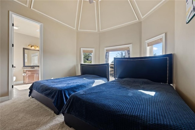 bedroom with connected bathroom, a high ceiling, and carpet