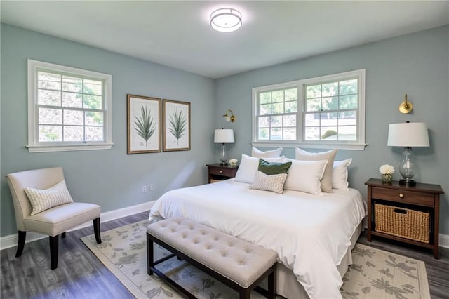 bedroom featuring multiple windows, wood finished floors, and baseboards