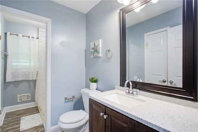 full bath with baseboards, toilet, visible vents, vanity, and wood finished floors
