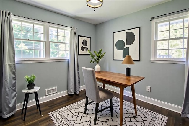 office featuring baseboards, visible vents, and dark wood finished floors