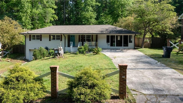 view of front of home with concrete driveway, a porch, a front lawn, and fence